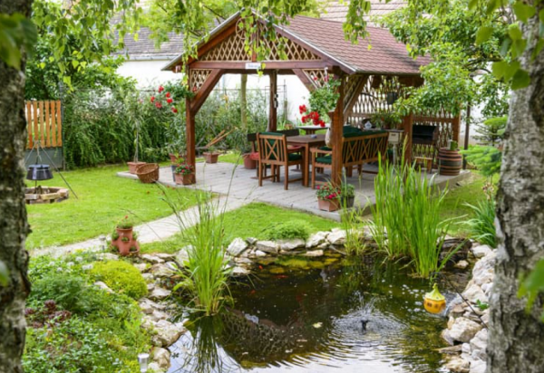 Taman dengan gazebo bambu dan kolam ikan